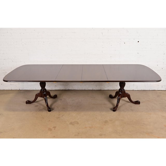 A gorgeous Georgian, Regency, or Queen Anne style banded mahogany double pedestal extension dining table In the manner of...