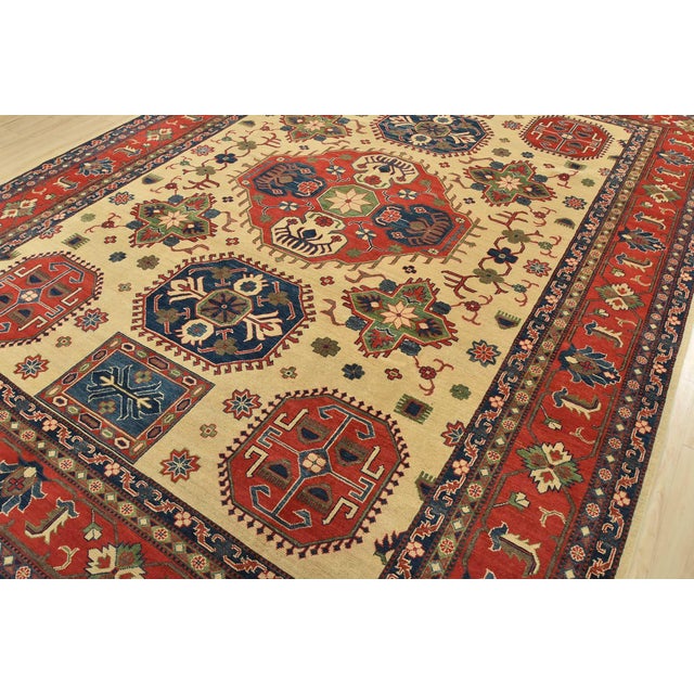 A tribal Kazak rug hand-knotted with fine wool on a cotton foundation. This oriental rug features a large central...