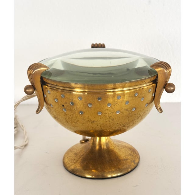 A small, elegant table lamp with a distinctive design, typical of high-quality Italian craftsmanship from the 1950s....
