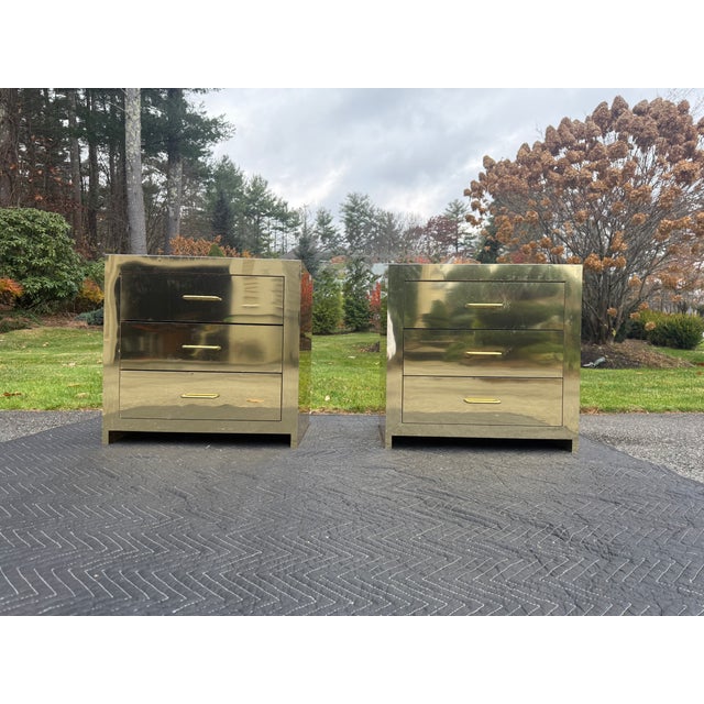 Gorgeous pair of brass clad three drawer bedside nightstands or small commodes. With brass exterior that reflects like a...