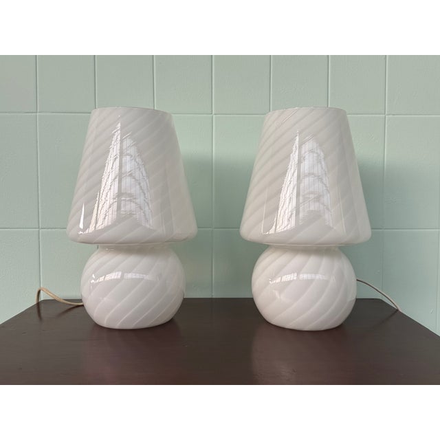This elegant pair of table lamps is crafted entirely of white opal glass, featuring a refined glossy finish and a delicate...