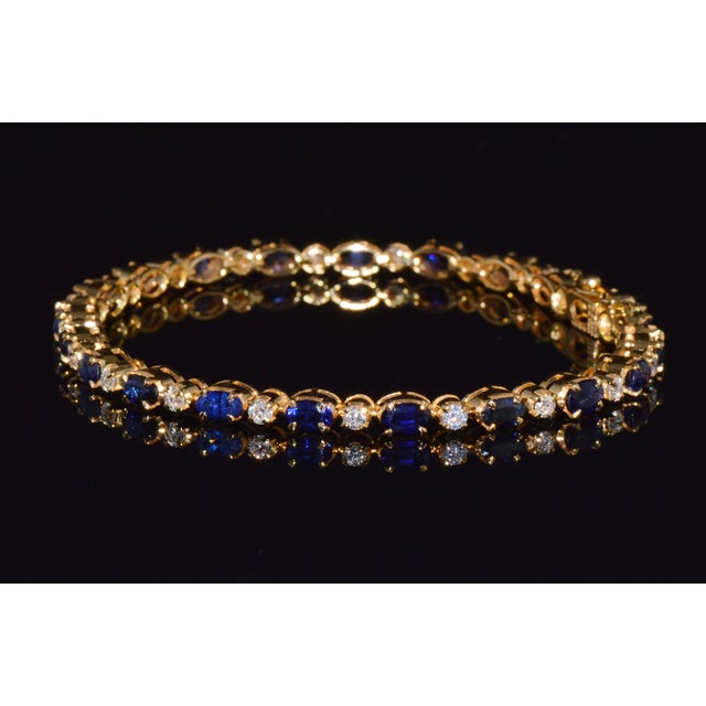 Gorgeous natural 7.09CTS diamond and blue sapphire tennis bracelet crafted in solid 18K yellow gold. This elegant bracelet...