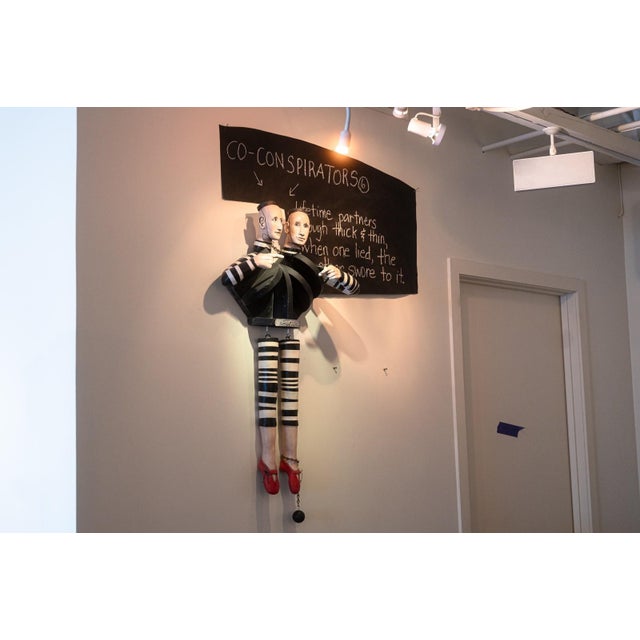 A contemporary mixed-media wall sculpture titled "Co-Conspirators" by Joan Rasmussen. Signed by artist on the lower right....