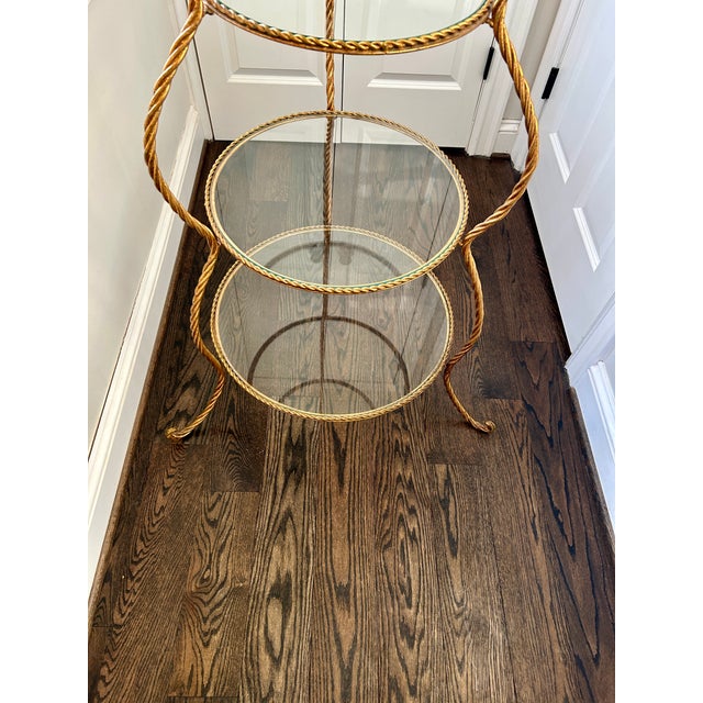 Gorgeous vintage Italian Hollywood Regency style gilt etagere. With four tiers and glass shelves, this piece is not only...
