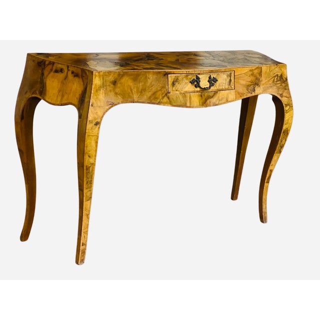 A stunning highly stylized Italian console table or low profile desk. It features a beautiful burl finish with one drawer...