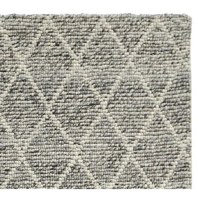 Soft gray and cream hand woven 100% wool rug with diamond lattice pattern. Durable construction and cotton canvas backing....