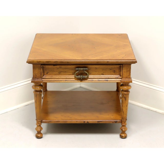 A Spanish style square end table by Drexel, from their Velero Collection. Pecan with distressed finish, parquetry top,...