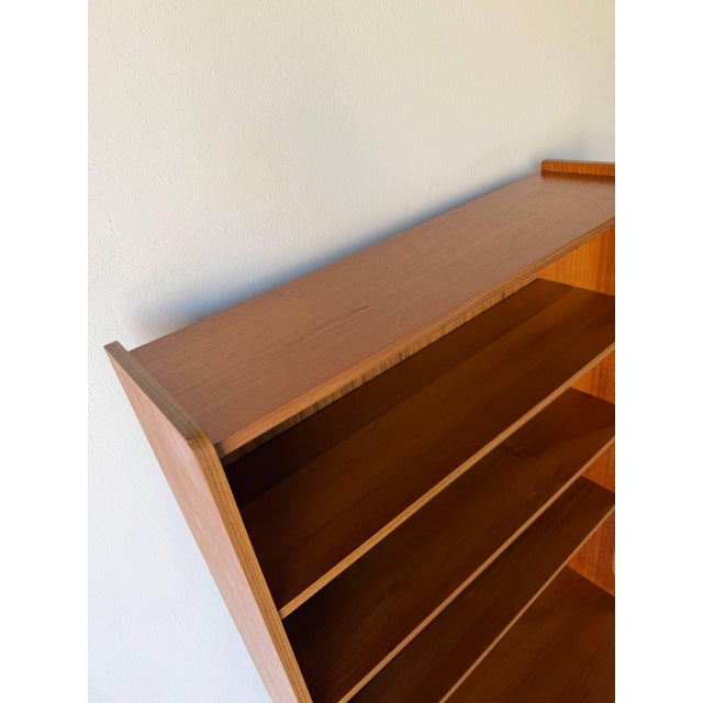 This beautiful vintage Danish teak bookcase is a classic example of Mid Century Modern Scandinavian design, combining open...