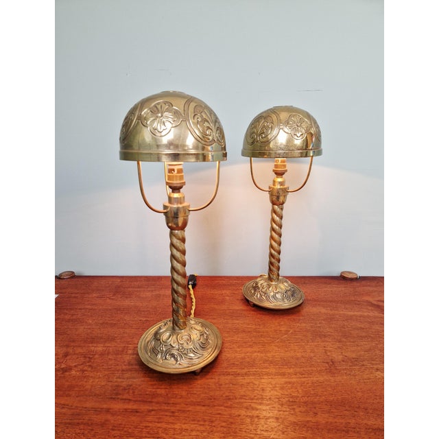 Pair of table lamps with twisted bronze bases and brass shades, dating from the early 20th century. Each lamp has been...