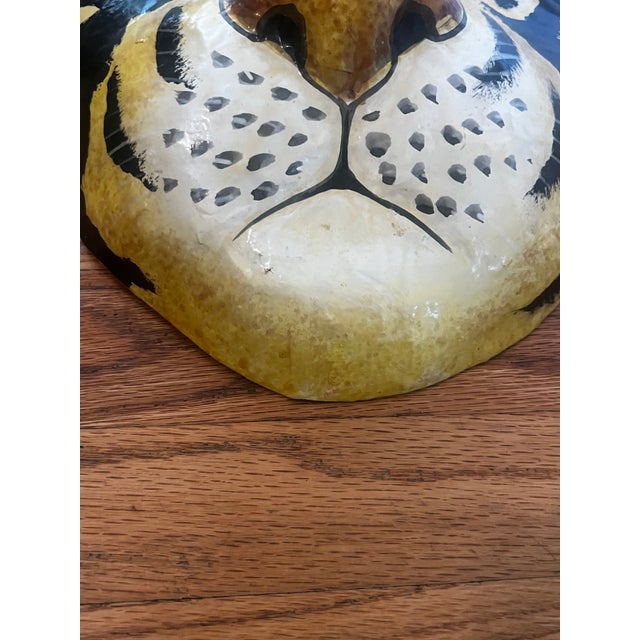 A bold and characterful paper mâché tiger face mask, hand-painted with impressive detail and personality. The tiger is...