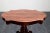 Carlo X table in solid cherry wood, with four finely carved curved legs connected to a central twisted trunk, supporting a...