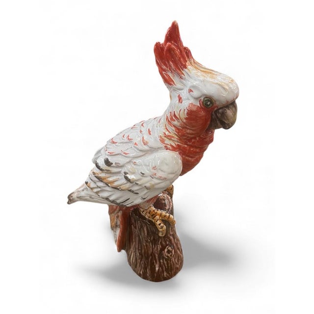This Italian ceramic sculpture depicts a Galah Cockatoo perched on a textured tree stump. Finished in a glossy palette of...