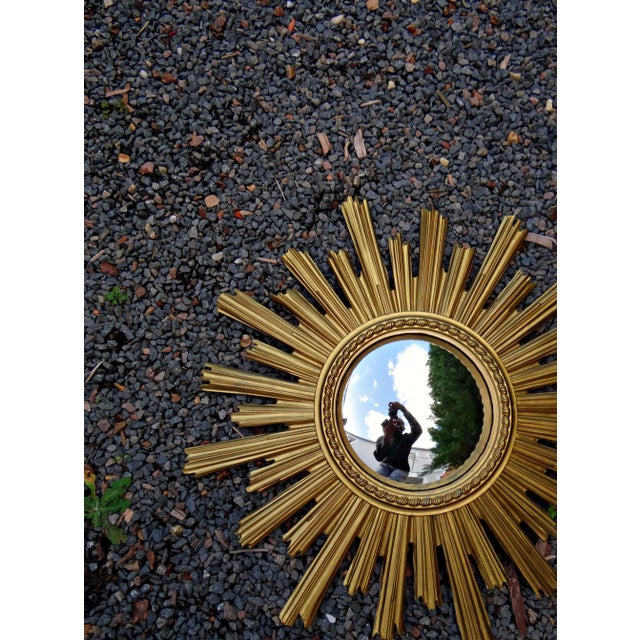 Mid-Century Witch's Eye Sunburst Mirror in Gold Resin, 1960s What if you invited the sun into your home? There's nothing...