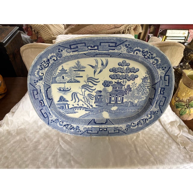 A large 19th C Staffordshire blue transfer ware meat platter in the Blue Willow pattern The piece is slightly deep to...