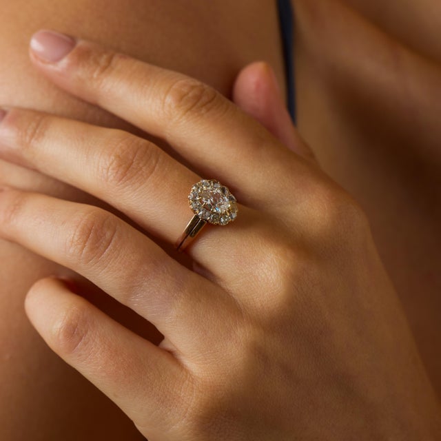 This Victorian diamond cluster engagement ring is a beautifully romantic antique piece from the 1900’s, crafted in warm...