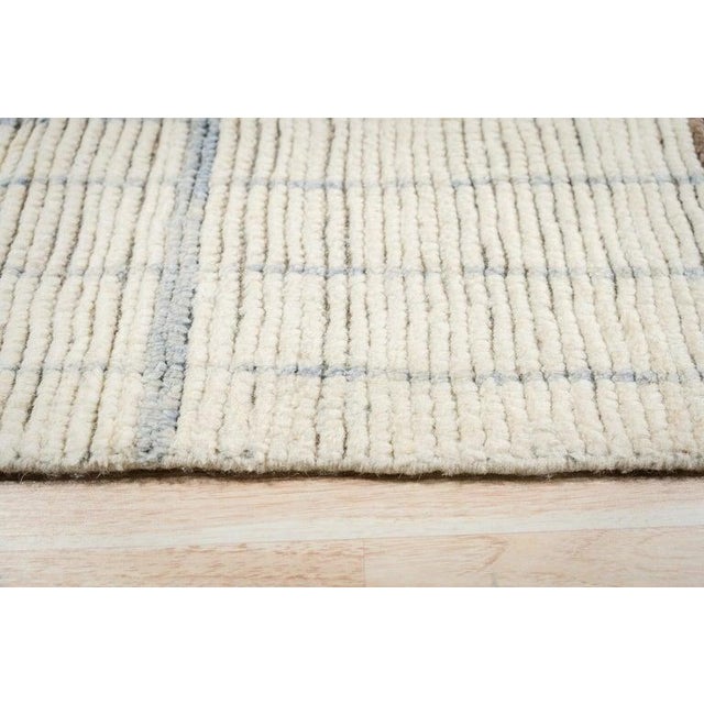 This ivory beige cream white rug is constructed from natural wool using a traditional hand knotted pile weave. Designed in...