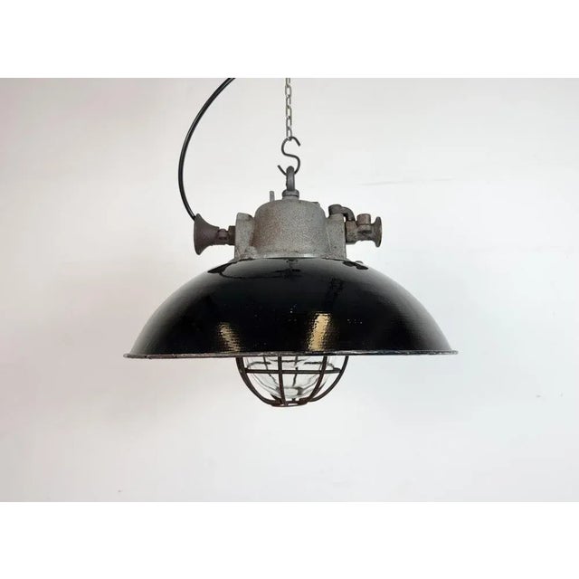 Industrial hanging lamp manufactured by Elektrosvit in former Czechoslovakia during the 1960s. It features a black enamel...