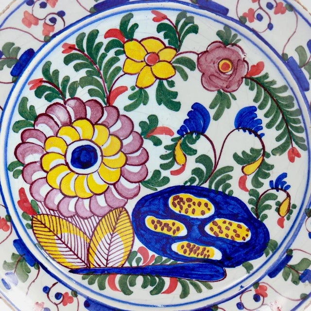 A fine antique Dutch Delft pottery plate. With a white porcelain ground richly decorated with blue, green, yellow and...