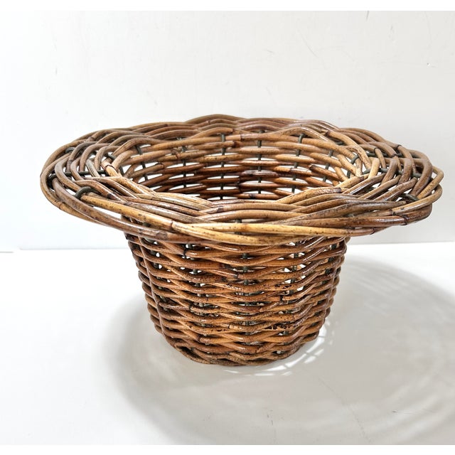 Vintage rattan pedestal basket with a flared rim and sculptural footed base, offering a more architectural take on classic...