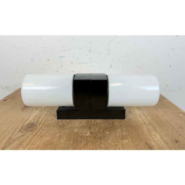 Vintage industrial brown bakelite wall lamp made in former Czechoslovakia during the 1960s. It features a bakelite wall...