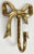 Vintage detailed brass ribbon bow wall hook with ceramic knob. Patina to brass.