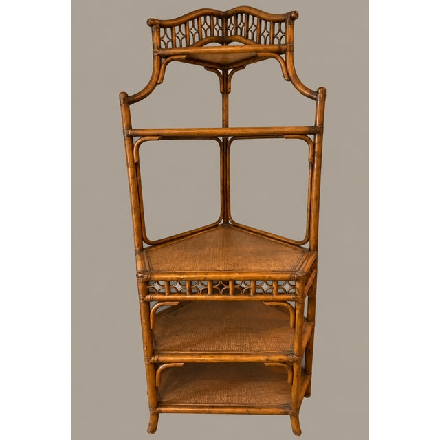 A beautifully detailed vintage rattan and bamboo corner étagère, featuring an elegant pagoda-inspired silhouette and...
