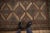 :: Diamond shaped repeating medallions in full and halved mapping with arrowed finials atop an abrashed ground and...