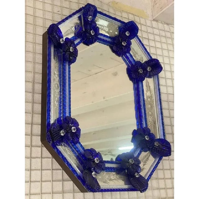 Important mirror with Murano glass style transparent elements and blue flowers. Octagonal mirror with venetian hand-carved...
