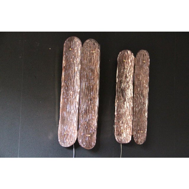 This exquisite pair of wall sconces was individually designed and crafted in Murano. Made from a rich, deep pink glass,...