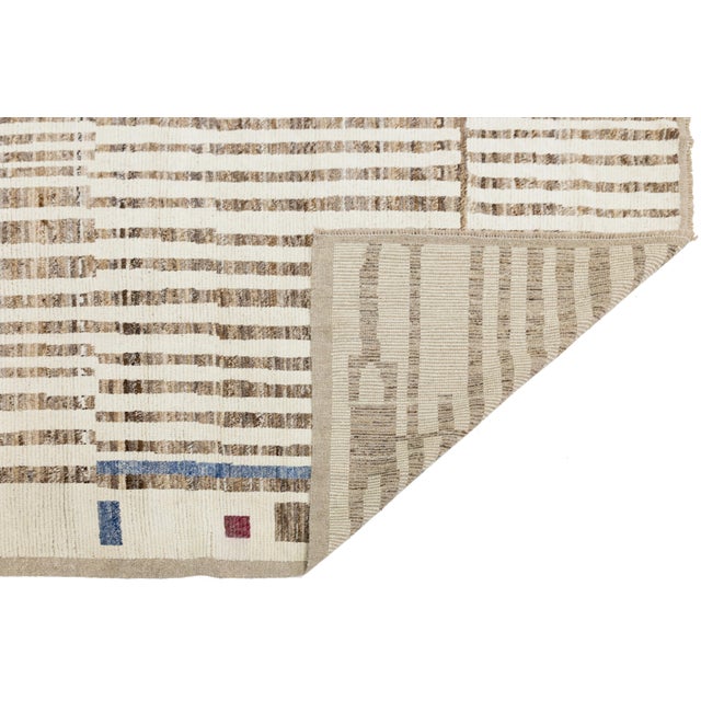 A striking modern Moroccan-style wool rug featuring vertical brown stripes and playful color blocks in blue, maroon, and...