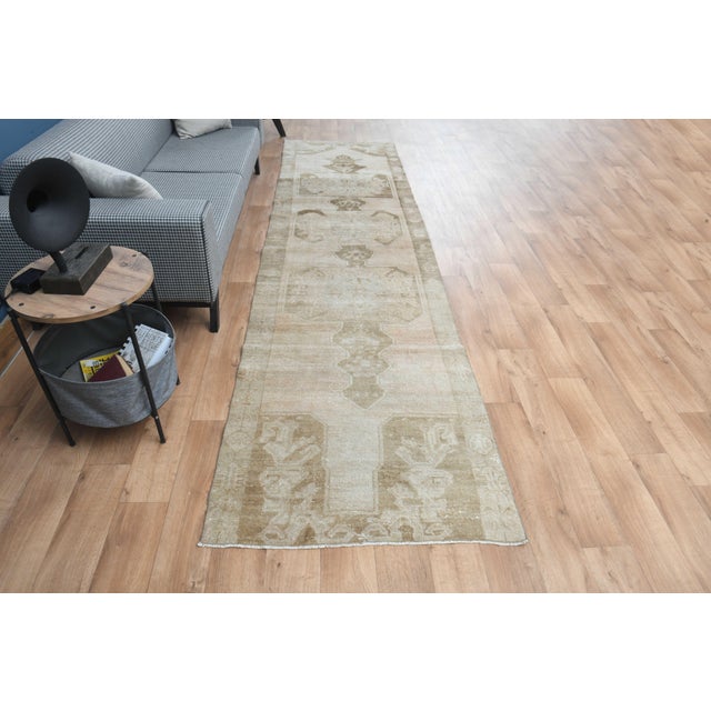 Vintage Hand-Knotted runner rug is a semi-antique vintage area rug. The '70s Eastern region of Anatolia's unique rug is...