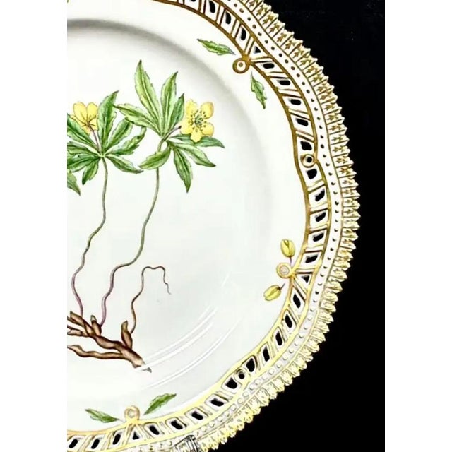 Royal Copenhagen Flora Danica Porcelain Plate, Anemone ranunculoides L, with Pierced Gilt Border. Each plate in this...