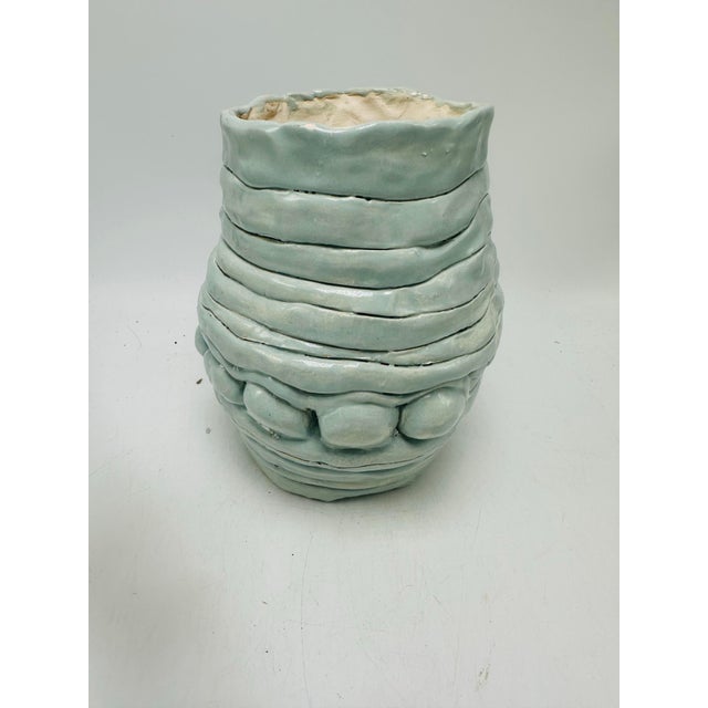 This is a hand-thrown studio pottery vase or planter with an organic, coastal-inspired design. Appearance • Rounded,...