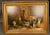 French oil on canvas depicting a still life with kittens, fruit, bottles, and bowls. Signed De Beer. Circa 1940. The...