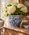 A classic blue and white porcelain planter, rendered in a softly faceted, scalloped form that feels both tailored and...
