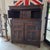 This English 17th-century carved oak court cupboard with intricate paneling, diamond-shaped carvings, and ornate turned...