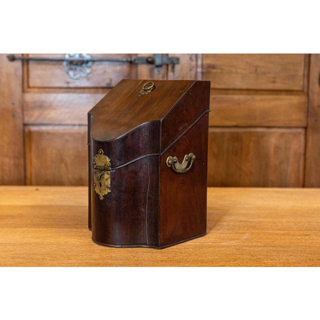 An English Georges III period walnut box from the early 18th century with slanted lid and brass hardware. This exquisite...