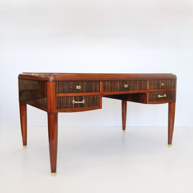 A fine Art Deco desk with five drawers. Beautiful hardwood veneers. Hardware of patinated bronze including round sabots...