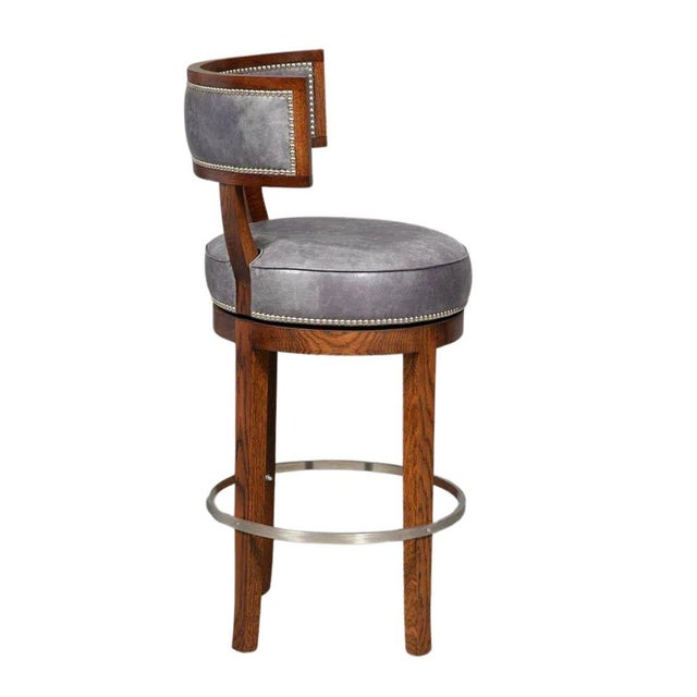A set of five Soane bar stools in blue leather with nail head trim, curved back and metal ring stretcher . Seats swivel....