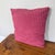 Square knife edge pillow in a raspberry pink woven ground with rows of raised cut velvet dots in a deeper berry shade....