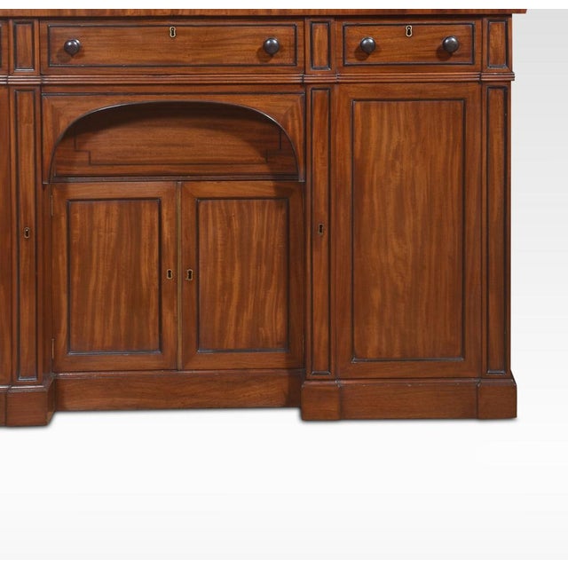 19th century Regency sideboard. The large rectangular well-figured top Above an arrangement of freeze drawers with ebonies...