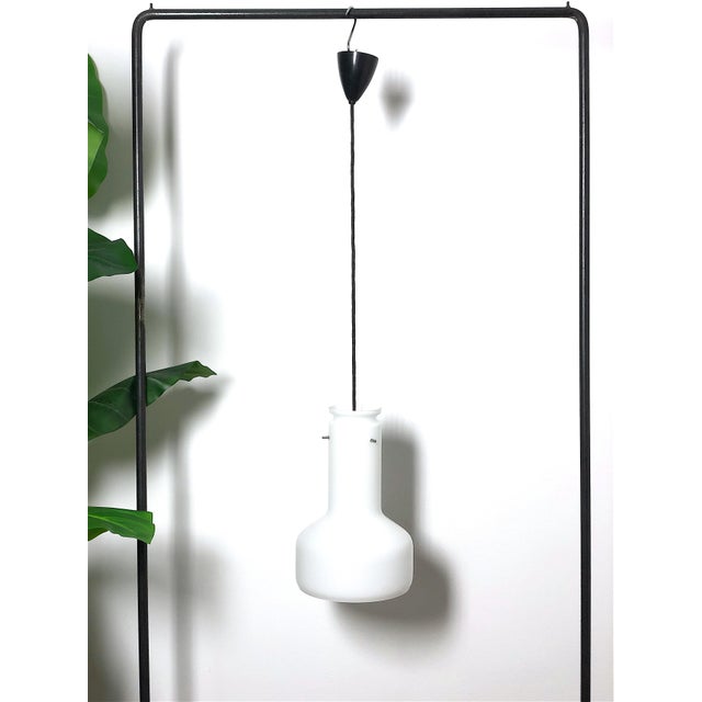 Refined pendant chandelier from the 1960s, characterized by a minimalist design and clean lines. The diffuser is made of...