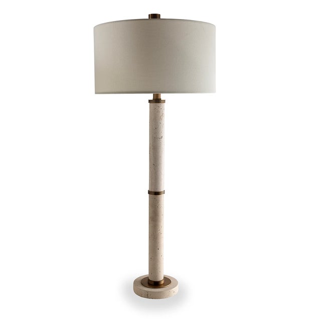 Natural unpolished stone marble turnings are accented with aged brass finished metal hardware for this Trivoli lamp. The...