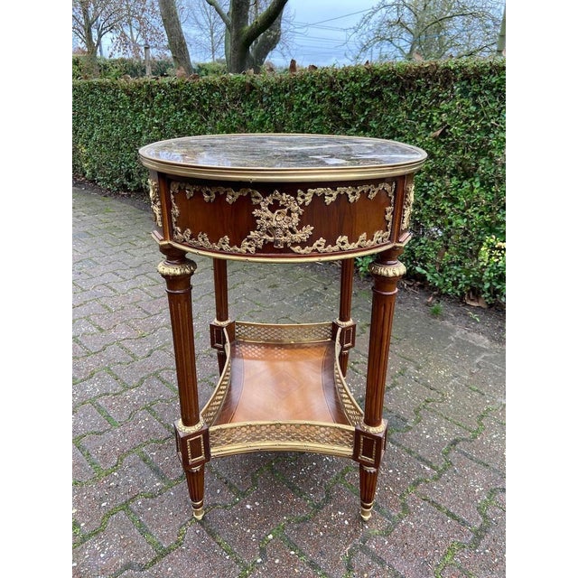 Late 20th Century French Louis XVI Mahogany Side Table with Marble Top Introduce timeless French refinement to your...