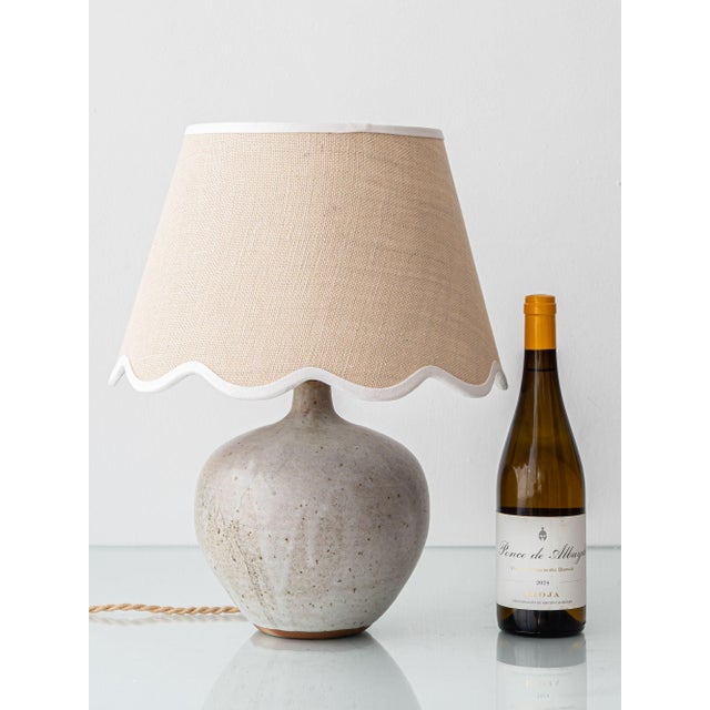 A mid-century French studio pottery stoneware table lamp by ceramist Robert Héraud, paired with a new woven jute scalloped...