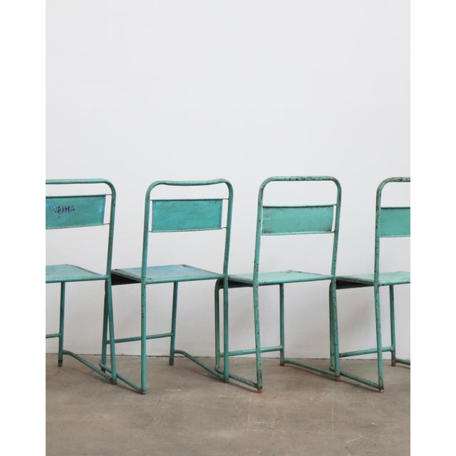 Set of four 20th-century Belgian industrial metal chairs with turquoise paint, as described in the original Salter LA...