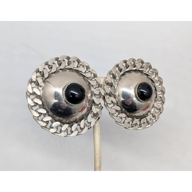 1970s silvertone and glass faux-onyx cabochon domed clip-back back earrings. Signed "U. Correani Made in Italy."...