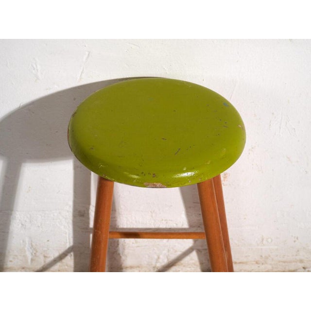 This antique wooden stool is a three-legged seat with a round seat and turned splayed legs joined by stretchers. It...