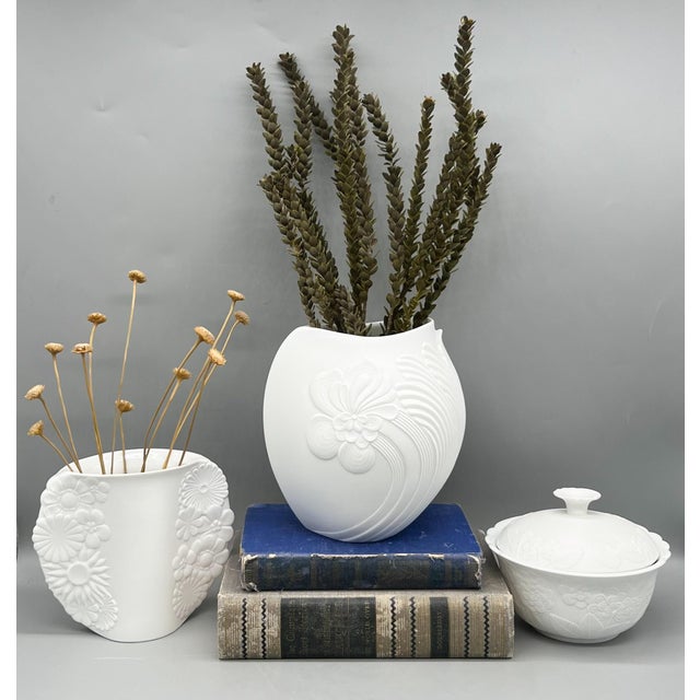 Elegant and timeless set of three white bisque porcelain vessels by Kaiser of West Germany, each featuring detailed raised...