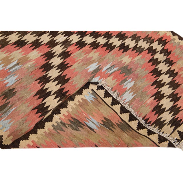 Beautiful vintage Turkish Kilim hand-knotted wool rug with a peach field. This piece has a beige frame and multicolor...